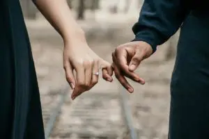 Buying a house together for the first time, A man and a woman holding pinkies