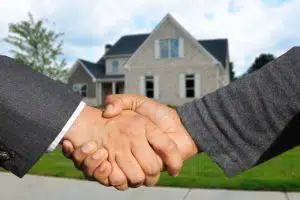 two people shaking hands after a house purchase 