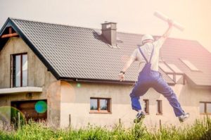 A happy contractor with a building permit in his hand jumping in the air, symbolizing the correct procedure for expanding your home in Clarksville TN.